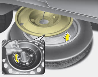 Kia Carnival: Removing the spare tire. 4. After the spare tire reaches the ground, continue to turn the wrench counterclockwise,